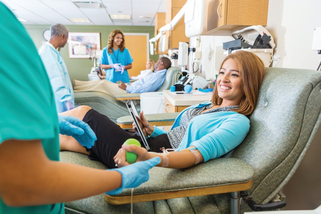 Woman donating blood with a big smile of satisfaction.